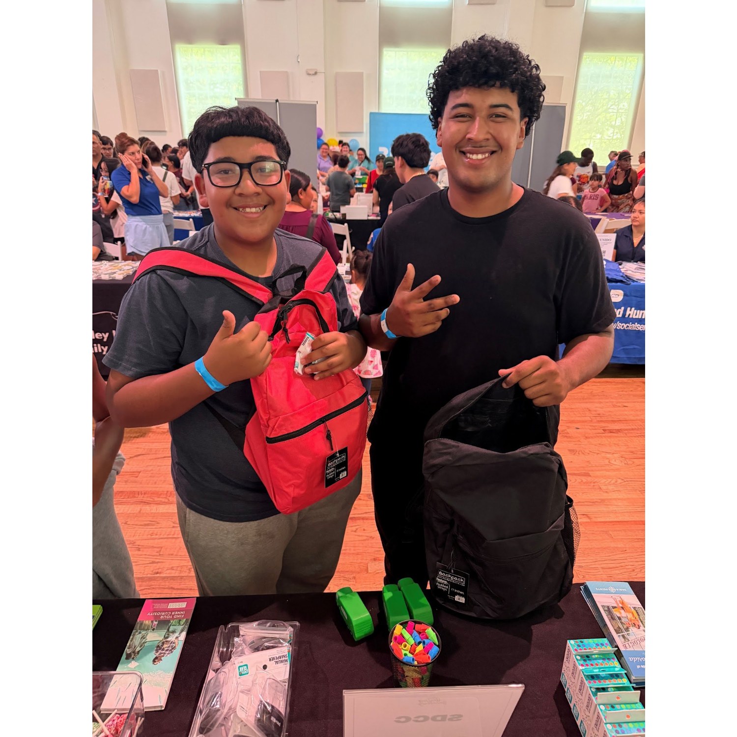 Two students smiling with new backpacks at a South Dade back-to-school event