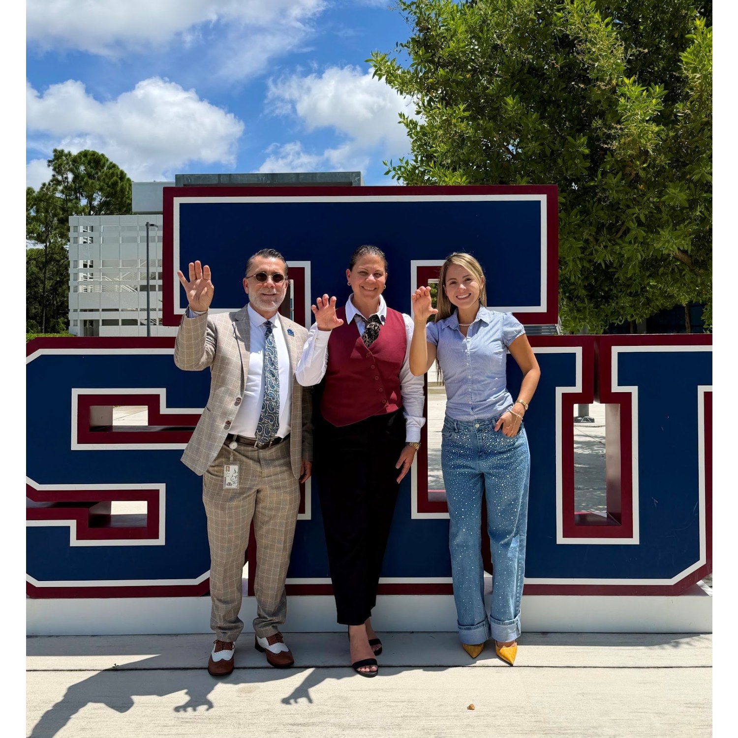 Chamber leaders in front of the St. Thomas University sign on campus