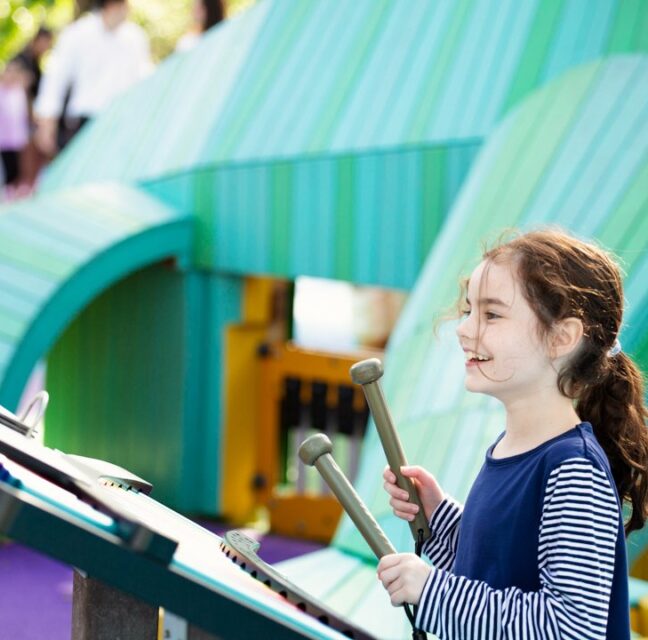 A child plays an outdoor instrument at the Pinecrest Gardens playground. Photo: Pinecrest Gardens